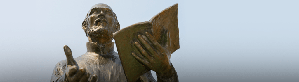 Statue of Ignatius of Loyola preaching with open Bible