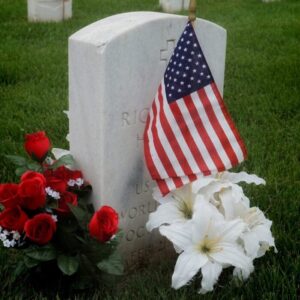 a grave with a flag and flowers on it