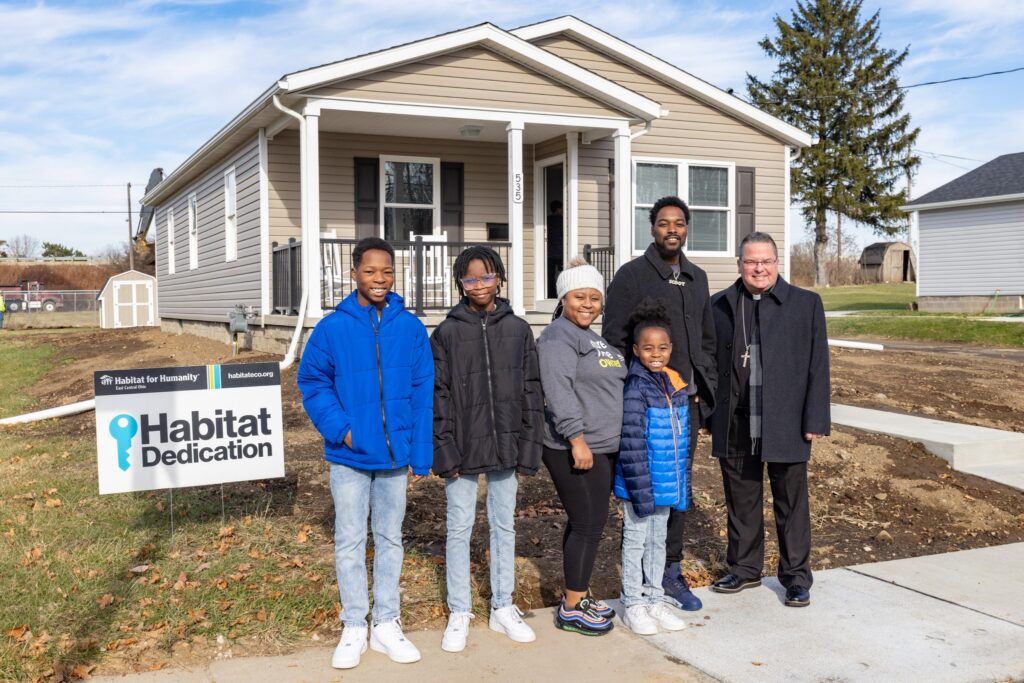 The Mathis family celebrates with Bishop David Bonnar at the dedication of their Habitat for Humanity home in Canton, Ohio on December 5, 2023