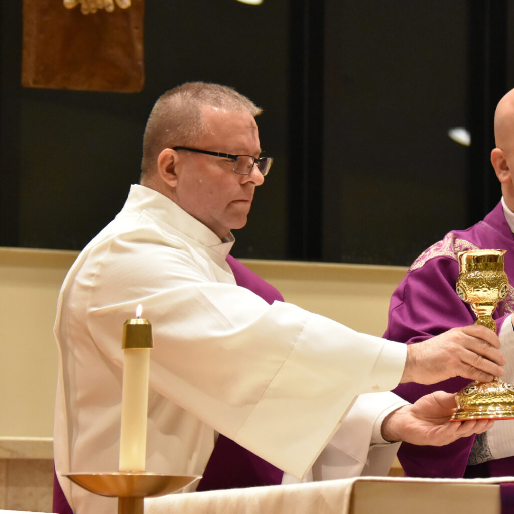 Deacon William Bancroft holds the chalice during the Eucharistic prayer on Ash Wednesday at St. Thomas Apostle Parish (Warren)