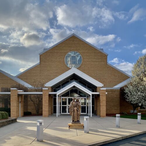 Front door of Holy Family Parish in Poland, Ohio with statue of the Holy Family in front