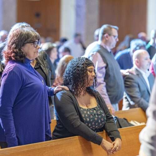 Sponsor has her hand on candidate's right shoulder at the Rite of Election, St. Columba Cathedral, February 18, 2024. Photo credit: Brian Keith.