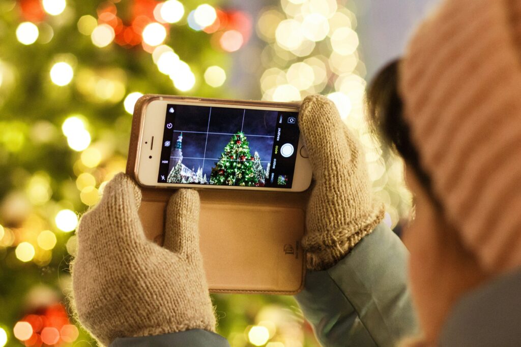 person taking photo of christmas tree