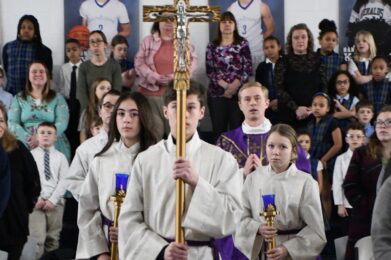 Servers wearing white and carrying cross and purple candles for Ash Wednesday