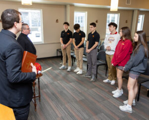 Rev. John Rovnak and Bishop David Connar speak with students at Cardinal Mooney High School