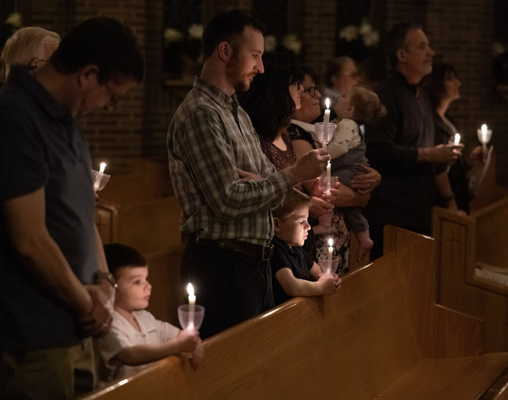 Families participate in the candlelight portion of Easter Vigil service at Little Flower Parish, North Canton on April 4, 2026. Photo credit: Bob Rossiter.
