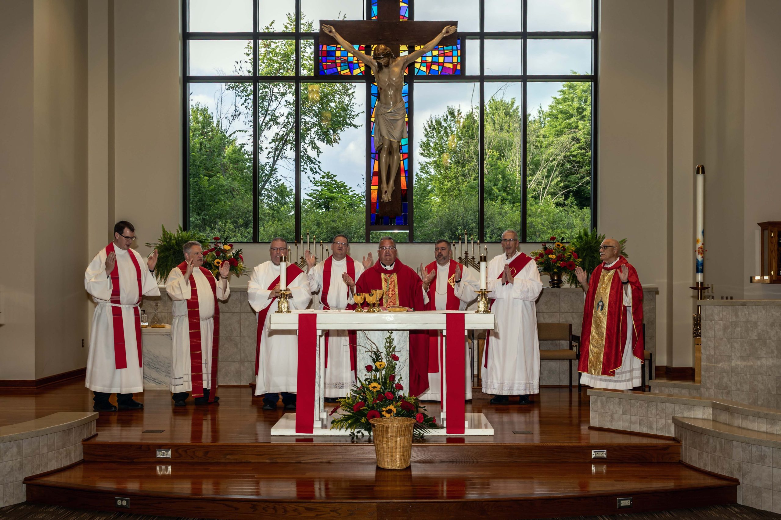 Bishop David J. Bonnar in red, white and gold liturgical vestments surrounded by priests and deacons at the altar at Saint Thomas the Apostle Church in Vienna on July 3, 2026